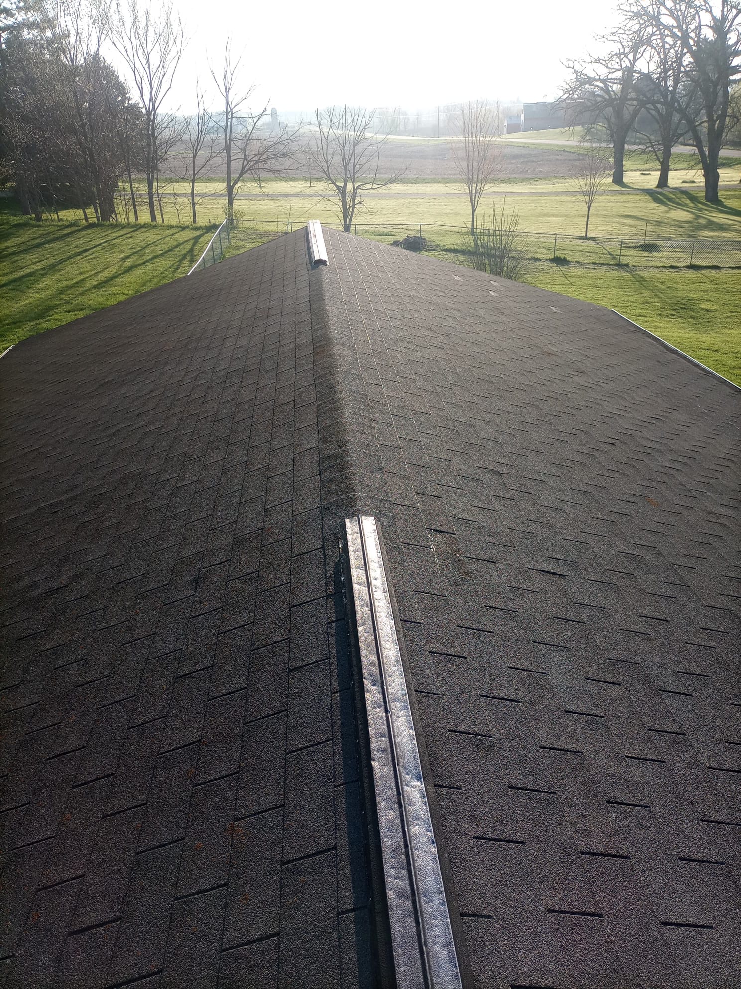 Completed asphalt shingle roof with a new ridge vent on a Madison, WI home
